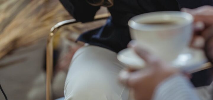 woman drinking coffee from ceramic cups during interview